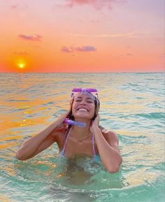 a woman is in the water with a mask and snorkels on her head