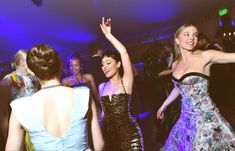 two women in evening dresses dancing at a party