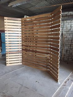 a room divider made out of wooden slats in an unfinished area with brick walls