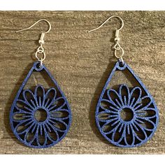 two pairs of blue earrings on top of a wooden table