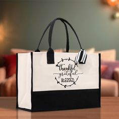 a black and white bag sitting on top of a wooden table