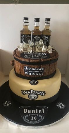 a cake made to look like an old barrel with whiskey bottles on top and ice cubes in the bottom