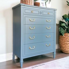 a blue dresser with gold handles in a living room