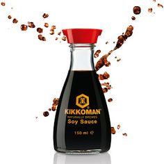 an image of a bottle of soy sauce being spilled into the air on a white background