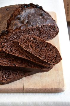 sliced loaf of chocolate bread sitting on top of a wooden cutting board