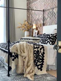 a black and white bed in a bedroom next to a window