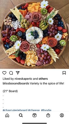 a bowl filled with lots of different types of fruit and veggies on top of a wooden floor