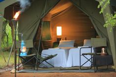 a tent set up with two chairs and a bed