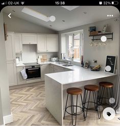 a kitchen with two stools next to an island