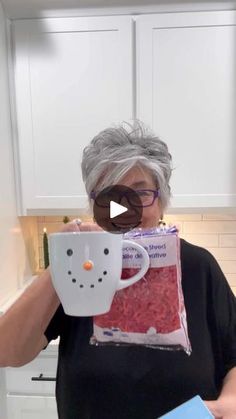 an older woman holding a mug in front of her face with red rice inside it