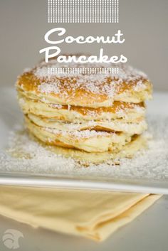 a stack of pancakes covered in powdered sugar on top of a white plate with the words coconut pancakes