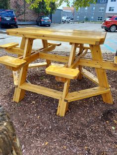 a wooden picnic table sitting in the middle of a park