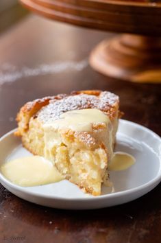 a piece of cake sitting on top of a white plate covered in powdered sugar