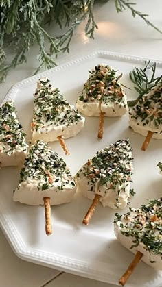 small appetizers are arranged on a white platter with rosemary sprigs