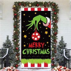 a christmas banner hanging from the side of a building with decorations around it and an elf's head on top