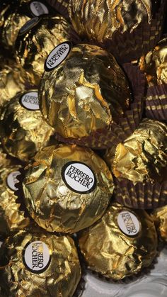 gold foiled chocolate eggs are stacked on top of each other