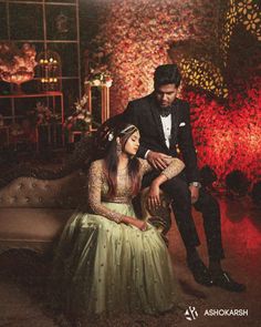 a man and woman in formal wear sitting on a couch