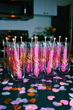 pink and gold confetti in wine glasses with straws on the table for valentine's day