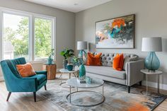 a living room with couches, chairs and lamps on the side tables in front of large windows