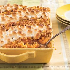 a yellow casserole dish filled with food on top of a table