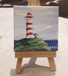 an easel with a painting of a lighthouse on it