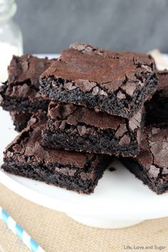 brownies stacked on top of each other on a white plate with one bite taken out