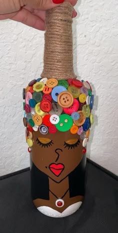 a bottle with buttons on it and a woman's face painted on the top