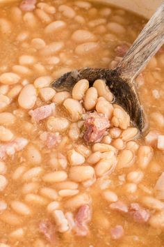 beans and ham are being stirred in a pot