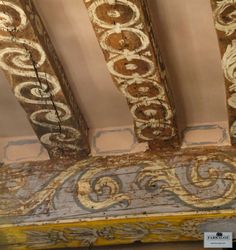 an ornately painted ceiling in a room with peeling paint on the walls and ceilings