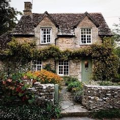 an old stone house with ivy growing on it