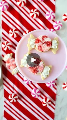 two decorated cookies on a plate with candy canes in the background and red and white striped napkin