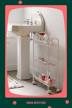 a white sink sitting next to a bath tub under a bathroom mirror on top of a pink frame