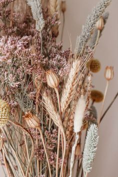 dried flowers are arranged in a vase on a table