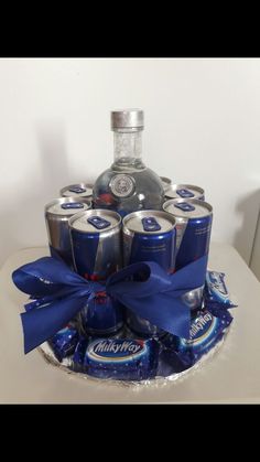 a birthday cake made to look like a bottle of liquor with blue ribbon around it