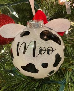 a christmas ornament with a cow face on it's head hanging from a tree