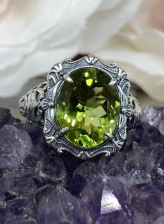 "Natural Green Peridot Ring Description Beauty Design#229 MADE To ORDER This is a brand new stunning Art Nouveau/Victorian reproduction sterling silver filigree ring. The oval-cut high-quality natural peridot is 12mm by 10mm (just shy of 3/8\" inch) in dimension... The ring is 5/8th of an inch (16.5mm) NS (long) on the finger. The ring and gem sit 7mm off the finger. The inside of the band is marked 925 for sterling. Notice the beautiful filigree swirl like the craftsmanship of the silver settin Wire Wrapped Stone Jewelry, Gemstone Art, Order Design, Wire Wrapping Stones, Leaf Garland, Beauty Design, Wire Rings, Peridot Ring, Sterling Silver Filigree