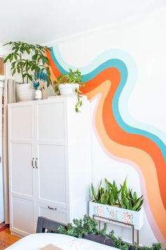 a room that has some plants on top of the cupboards in front of it