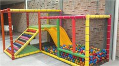 an indoor play area for children with colorful balls in it and a slide on the ground