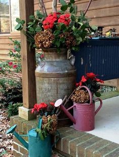 two buckets filled with flowers sitting on the side of a house