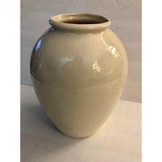 a large white vase sitting on top of a table