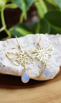 Add a touch of magic to your jewelry collection with these Gold Opalite Moth Dangle Earrings. Crafted with intricate 18x33mm laser-cut brass moth charms and gold plated 8x12mm opalite crystals. The opalite's iridescent glow adds a mystical, fairy like charm to the design, making them perfect for those who love whimsical jewelry.

They are lightweight and made with gold plated stainless steel hooks making them ideal for sensitive ears.

These earrings make a great gift for anyone who loves fairies, nature, or mystical jewelry! Mystical Fairy, Moth Earrings, Opalite Crystal, Mystical Jewelry, Whimsical Jewelry, Iridescent Crystal, Vintage Style Jewellery, Asheville Nc, Sensitive Ears