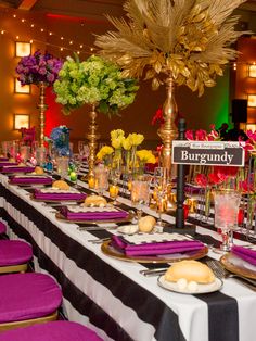 a long table is set with purple napkins and place settings for the guests to eat