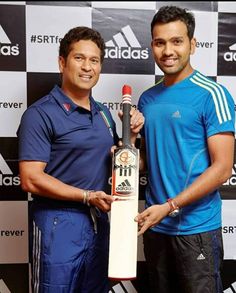 two men standing next to each other holding a bottle and a bat in their hands