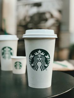 three starbucks cups sitting on top of a table