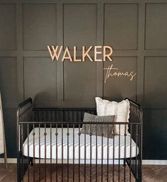 a black metal crib sitting in front of a wall with the word walker on it