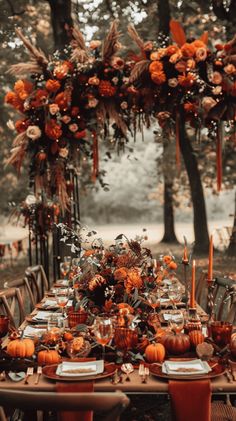 an outdoor table set with pumpkins, candles and greenery for a fall wedding