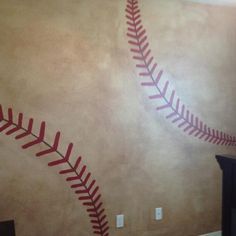 a baseball themed wall in a child's room with red and white stitches on it