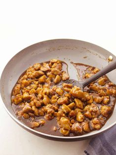 a pan filled with meat and sauce on top of a table