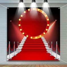 an empty stage with red carpet and stairs lit by spotlights, surrounded by rope barriers