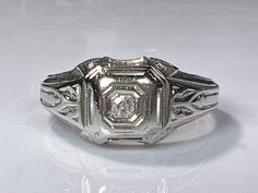 "Very sweet antique diamond ring in 18K white gold from the Art Deco era. This pretty ring features an antique natural mine cut natural diamond in a classic Art Deco setting. The diamond is a very high quality VS diamond and measures 2mm. In excellent condition with a solid ring shank all around. Ring size 9 and easily sized up or down several sizes. Ring sizing service available; please see sizing fees listed below. Please allow one week for sizing. One month layaway payment plans on items $500 and over available. Approximate Age - Art Deco Gemstone(s)  - natural diamond, Old Mine Cut Metal - 18K white gold Weight - 4.43 grams Ring size - 9 Marks - 18K Makers Mark -  Comments -  Service & Sizing Information: If you require ring sizing or service, kindly follow the link below to add the ap Victorian Diamond Ring In White Gold, Victorian White Gold Diamond Ring, Victorian Platinum Diamond Ring With Single Cut Diamonds, Victorian Diamond White Diamond Ring, Victorian Style Diamond White Round Cut Diamond Ring, Victorian Style Diamond White Diamond Ring, Victorian White Diamond Ring In Platinum, Victorian White Diamond Platinum Ring, Victorian Style White Diamond Platinum Ring